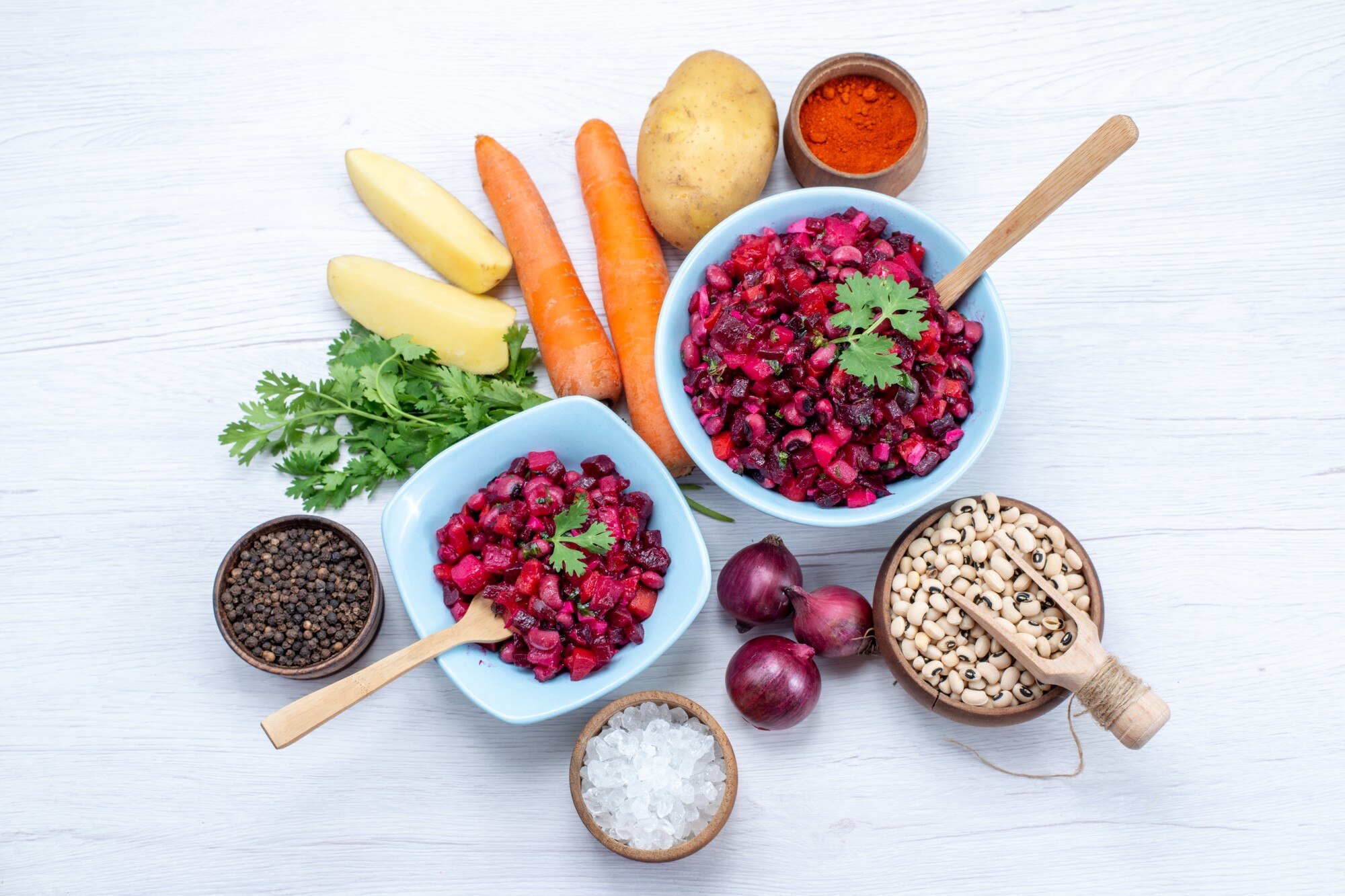 Vista cenital de una comida colorida y variada con verduras, cereales y legumbres sobre fondo claro